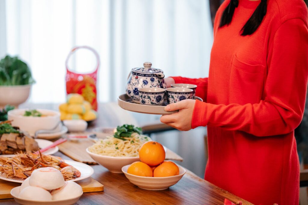 A vibrant spread for Chinese New Year celebration featuring traditional dishes and tea set.