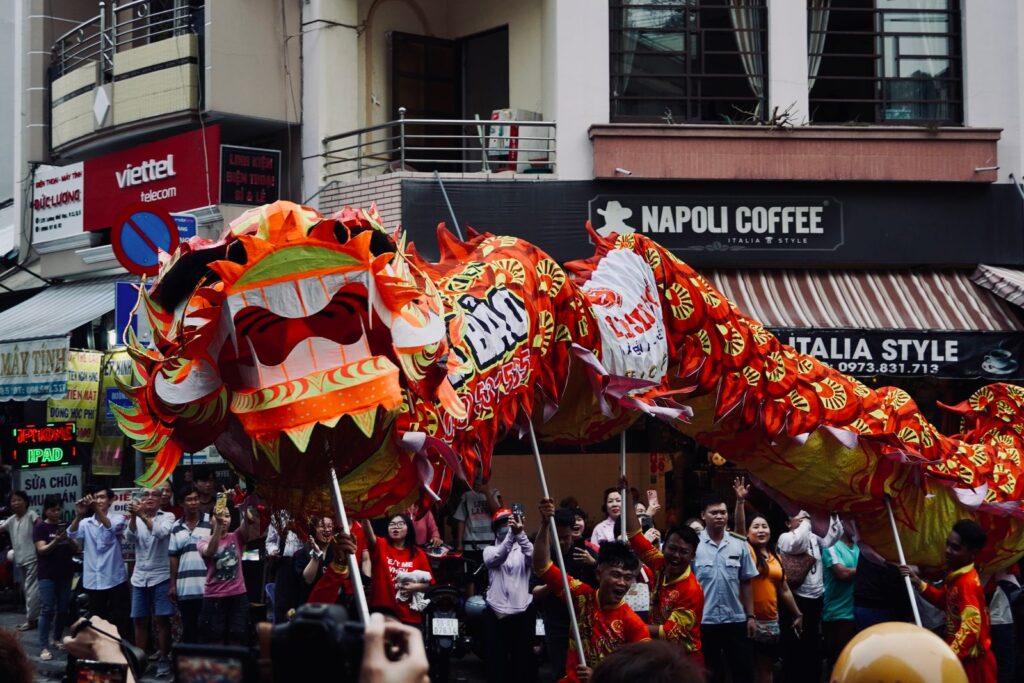 Colorful dragon dance performance captivates crowd in lively street festival setting.