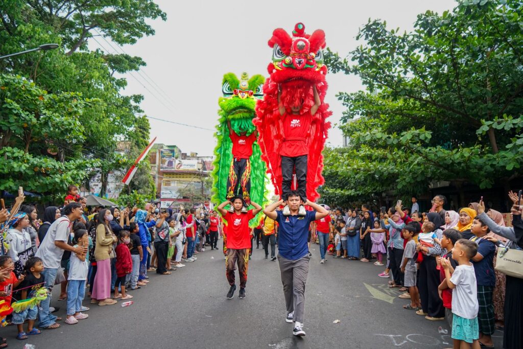 Vibrant lion dance at street festival with performers and crowd in attendance.