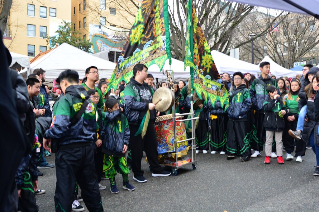 Musicians in the street playing for lion dance on a sidewalk in the International District, Seattle, Washington, during Lunar New Year.